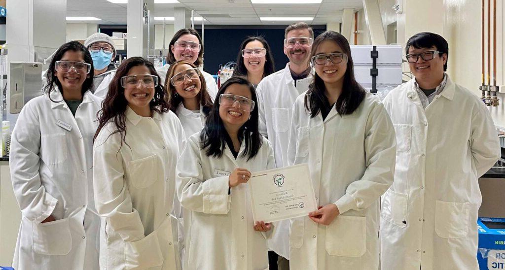 博彩平台网址大全's Manufacturing Sciences and Technology team holding a My Green Lab certification in a laboratory